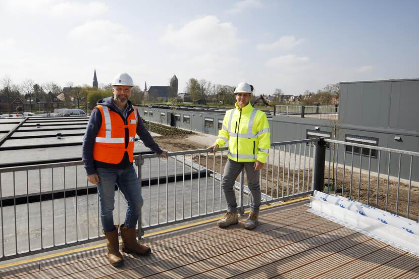 Wil en Jaap staan op het dak van het nieuwe zorgcentrum met op de achtergrond de skyline van Bedum